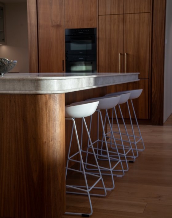 Walnut kitchen island with white bar stools