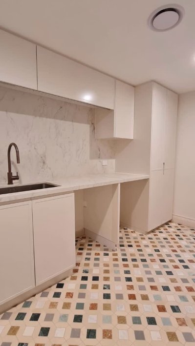 White kitchen with marble splashback and mosaic floor